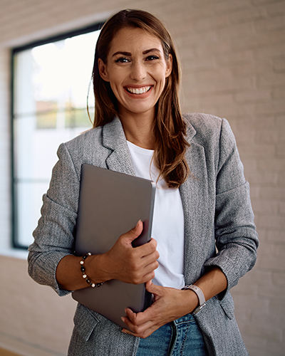 Portrait of young happy businesswoman in the office looking at camera.